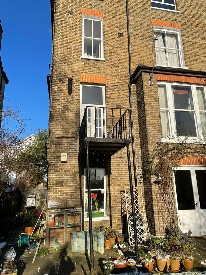 The rear of the house before works, with its original iron balcony